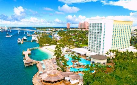 Aerial view of a resort tower, pools and marina on Paradise Island
