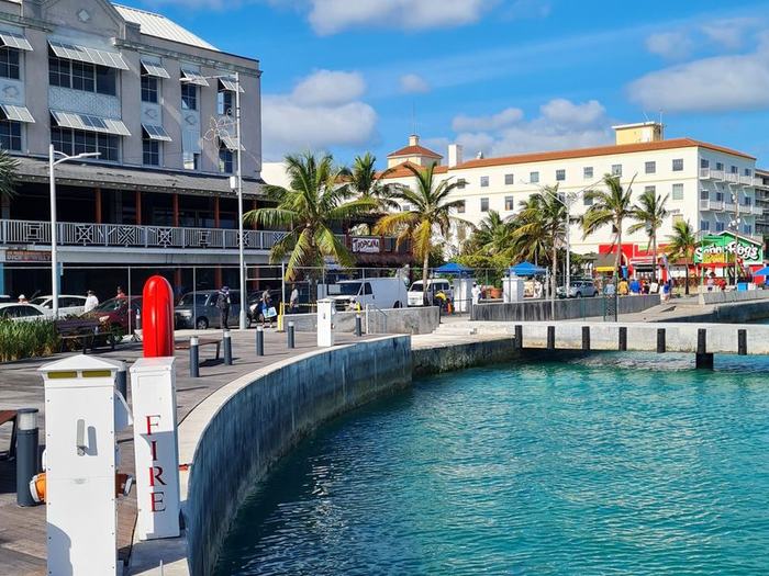 Nassau waterfront promenade with palm trees and colorful shops on a sunny day